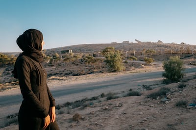 Houyem Abdallah looks on as hundreds of tonnes of waste transported from the large costal city of Sfax are deposited in the landfill on the outskirts of her town. Photo: Erin Clare Brown / The National