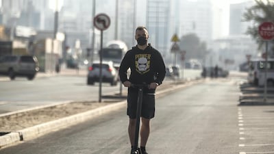 A man rides an electric scooter down a one way road in the Al Quoz district of Dubai. Antonie Robertson/The National