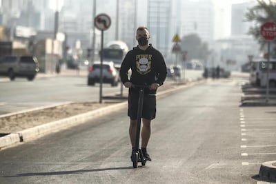 A man rides an electric scooter down a one way road in the Al Quoz district of Dubai. Antonie Robertson/The National