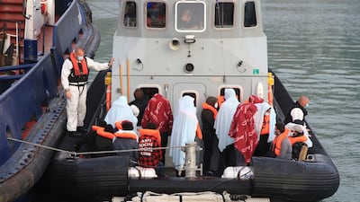 A group of people thought to be migrants are brought to the harbour in Dover, Kent. AP