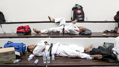 Fighters rest behind the stage at Al Ain Jiu Jitsu Open Championship. Reem Mohammed / The National