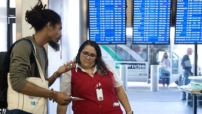 A Delta employee helps a traveller near the Delta check-in counter at LaGuardia Airport. AFP