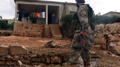 A member of the Free Syrian Army talks to residents who stayed on in Harem town, Idlib, despite fighting between the rebels and pro-government forces for control of the town. A four-day truce for Eid should give residents some respite from this morning.