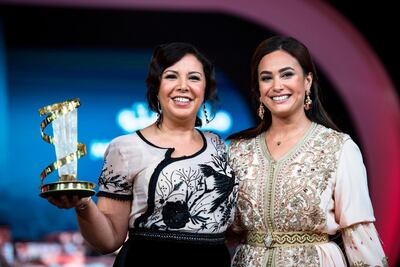 Moroccan actress Mouna Fettou (L) receives a tribute award from Tunisian actress Hend Sabry (R). AFP