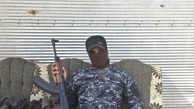 Abdelyusef, no last name given, an Iraqi Federal Police officer, poses for a portrait at a checkpoint in the village of Al Kut.