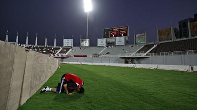 Al Wahda's goalkeeping coach Adel Al Mamor offers Isha prayers during half time of the team's game against Al Ahli.