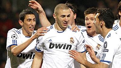Karim Benzema, centre, is congratulated by his Real Madrid teammates after putting his side 1-0 up in their 1-1 draw with Lyon.