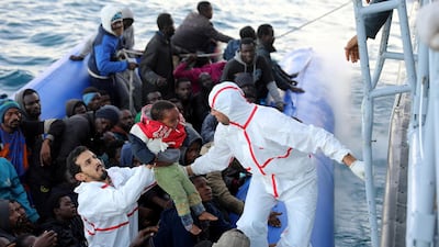 A child is handed over to Libyan coast guards who rescued the dinghy passengers off the coast of Garabulli, east of Tripoli. REUTERS/Hani Amara TPX IMAGES OF THE DAY