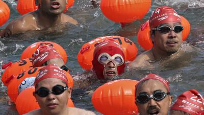 A competitor, centre, wearing a facekini joins other swimmers during the annual 1.5 kilometre harbour race at the Victoria Harbour in Hong Kong. A record 2,500 of swimmers took part in the cross harbour swim this year. Kin Cheung / AP