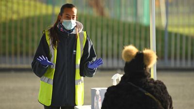 A worker speaks to a member of the public at a testing facility in Liverpool. AFP
