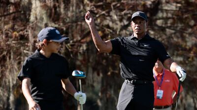 Tiger Woods tosses a tee at Charlie Woods. AFP