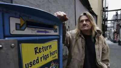 Earl Crowe, a former heroin user who used the Insite safe injection site, stands near a needle disposal unit in Vancouver, British Columbia.