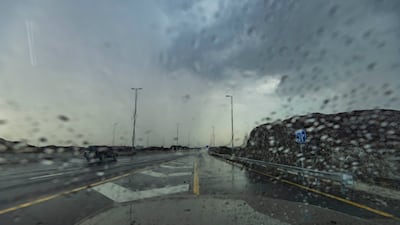 Rain falls on the Wadi Shawka road on Tuesday. Antonie Robertson/The National