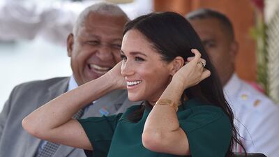 Meghan smiles beside Fiji's Prime Minister Frank Bainimarama. AFP