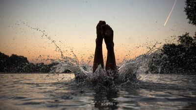 Swimmers enjoy an early morning dip shortly before sunrise in the Serpentine in Hyde Park, London. Dan Kitwood / Getty Images