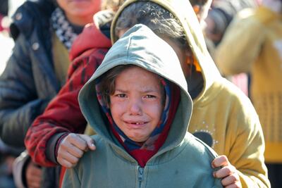 A child cries as Palestinians gather to receive food cooked by a charity kitchen, amid a hunger crisis in Gaza's southern area of Khan Younis. Reuters