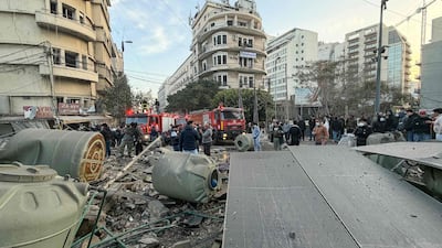Firefighters and people gather at the site of the Israeli air strike. AFP