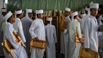Students in Bentong, outside Kuala Lumpur carry their wooden rehals, a foldable bookrest used for placing the Quran when reading and reciting, after completing their studies. AFP