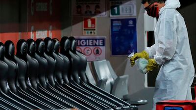 A worker sanitizes the reserve bench during the closed-door Copa Libertadores group phase football match between Brazil's Athletico Paranaense and Bolivia's Jorge Wilstermann at the Arena da Baixada stadium in Curitiba, Brazil. AFP
