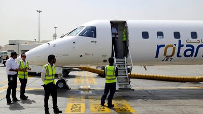 Ground staff wait by the Rotana Jet flight from Abu Dhabi to Dubai.