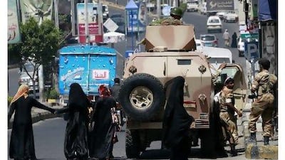 Women walk near an armoured personnel carrier in the Yemeni city of Taiz Thursday. Yemen's opposition rejected an offer on Thursday to join Gulf-mediated talks in Saudi Arabia on a transfer of power for President Ali Abdullah Saleh.