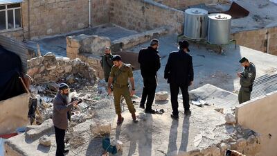 Israeli soldiers and settlers stand over a Palestinian house near the Ibrahimi mosque, also known as cave of patriarchs, in the West Bank city of Hebron. Local reports state the Israeli army informed the owners of the house that the army will take over the house. EPA