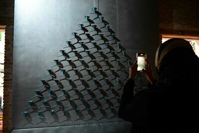 A visitor takes a photo of 'Fountain of Exhaustion' by artist Pavlo Makov at Ukraine's pavilion. AFP