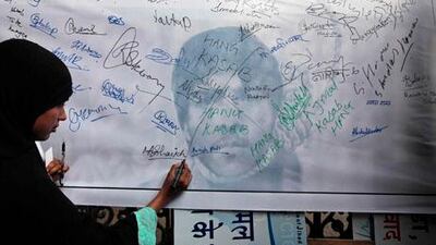 A woman signs a banner demanding the execution of convicted terrorist Ajmal Kasab, at Chhatrapati Shivaji train station in Mumbai. Kasab, the only gunman to survive the assault, has been sentenced to death in India, but none of the seven alleged masterminds in Pakistan has been put on trial.