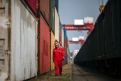 A worker walks next to containers in the China-Kazakhstan Logistic Base in Jiangsu province, China on September 17, 2021. EPA