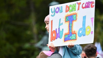 A child holds a placard with the slogan 'you don't care but I do!'. Reuters