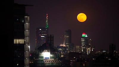 The supermoon passes in the night sky behind the high-rise buildings in Milan, Italy. EPA