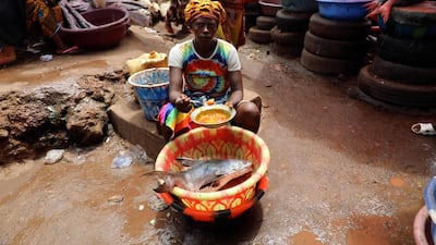 A Tombo market trader prepares a marinade for fish caught in the morning’s haul to sell at her restaurant. Andy Scott / The National