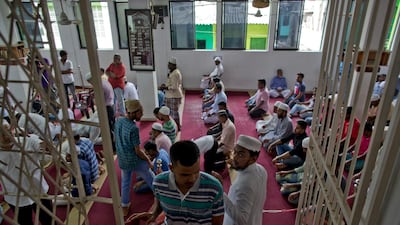 A volunteer assigned to spot unfamiliar visitors looks at a man inside a mosque in Colombo. AP Photo