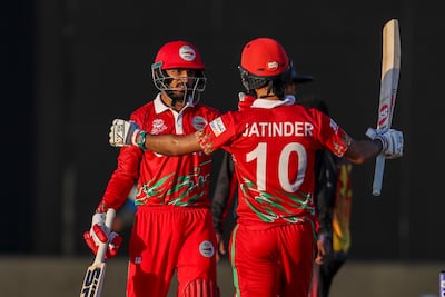 Oman's Aqib Ilyas, left, and teammate Jatinder Singh celebrate after defeating Papua New Guinea by 10 wickets in their T20 World Cup first-round match in Muscat on October 17, 2021. AP