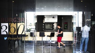 A fire at a ground floor restaurant Burger 360 forced Marina Tower in Dubai to evacuate its tenants. Seen here, walking by while cleaning the restaurant is Avelino, an employee at the resurant. Lee Hoagland/The National