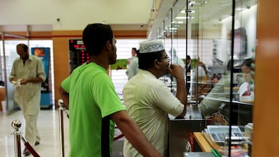 Expatriate workers send funds to their home countries at an exchange in Abu Dhabi. Christopher Pike / The National