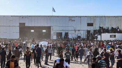 Displaced Palestinians carry bags of food aid after storming a World Food Programme warehouse. AFP