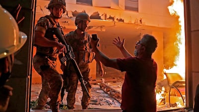 A Lebanese protester speaks to soldiers at the headquarters of the Lebanese association of banks in downtown Beirut. AFP