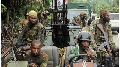Alassane Ouattara's FRCI soldiers ride an armed vehicle as they prepare for the so-called 'final assault' in front of the Golf hotel in Abidjan.