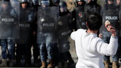 An anti-government protester holds a knife as throws stones at riot police during a scuffle near the parliament building in downtown Beirut. AP Photo
