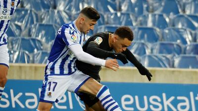 Real Sociedad midfielder Martin Merquelanz vies for the ball against Barcelona defender Serginho Dest. EPA