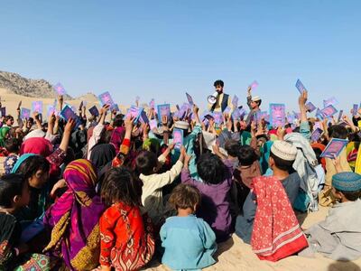 A young Pen Path volunteer reads to children. Photo: Pen Path Volunteers