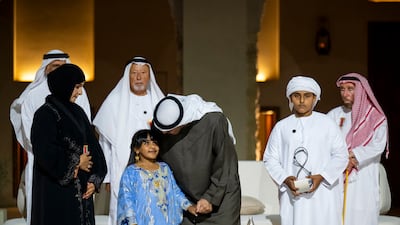 Sheikh Mohamed greets a young family member of Abu Dhabi Award winner Fatima Al Mansoori