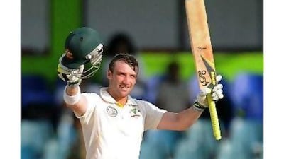 Phillip Hughes raises his bat to celebrate a third Test hundred, which he scored at a fast clip with one six and 16 fours.