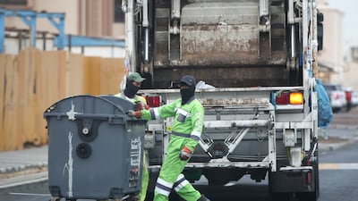 Sanitation workers at Khalifa City on a rainy cool morning.