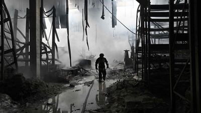 A Ukrainian firefighter walks amid rubble in a shopping mall following a Russian shelling in Kherson. AFP