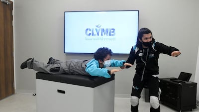 Instructor Richard Manalaysay teaches Samih, 9, techniques and communication signs before the indoor skydiving session.