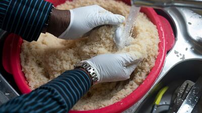 Volunteer Dave Williams washes rice as members of the Preston Windrush Covid Response team prepare meals. AP Photo