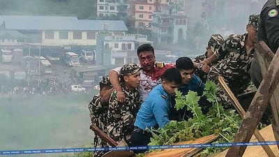 Rescuers carry the injured pilot to safety. AFP