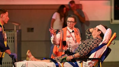 Health workers move a woman on to a stretcher. AFP